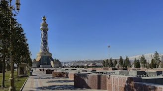 a monument with a light tower in the background