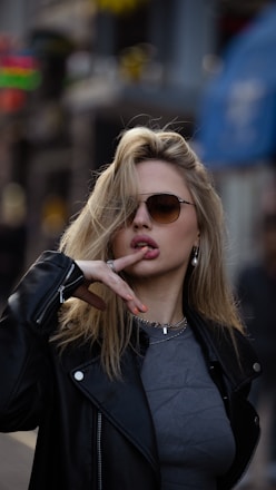 a woman in a leather jacket smoking a cigarette