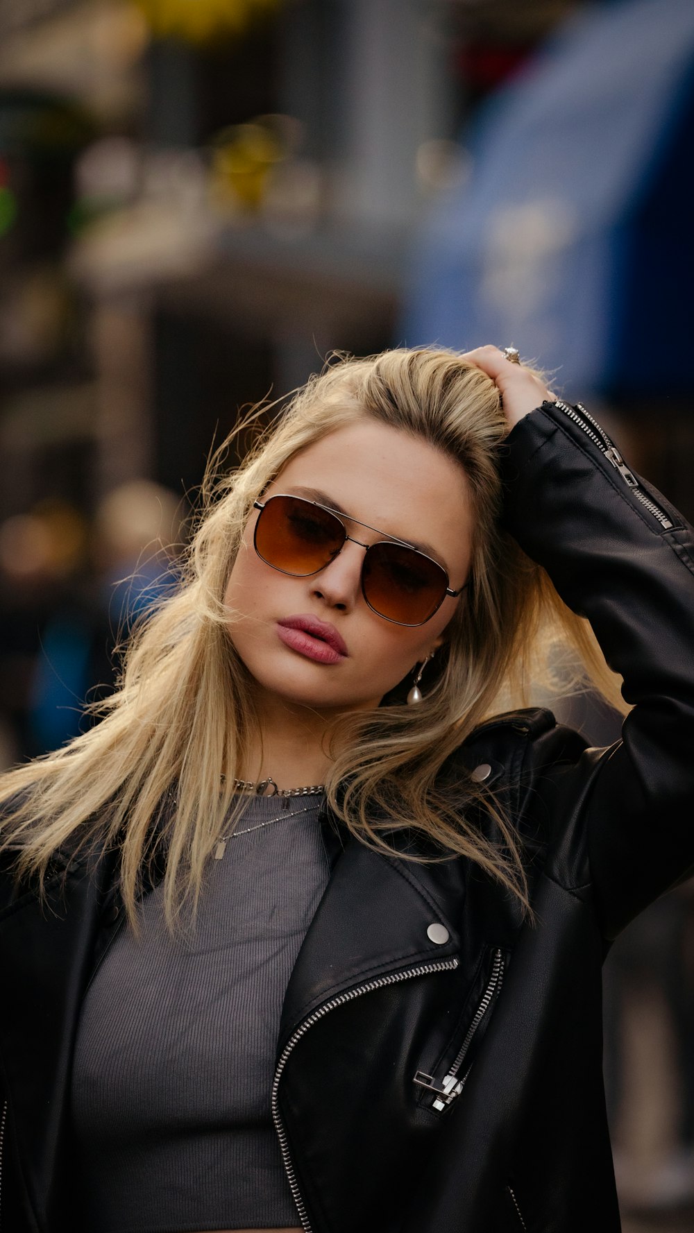 a woman in a leather jacket and sunglasses