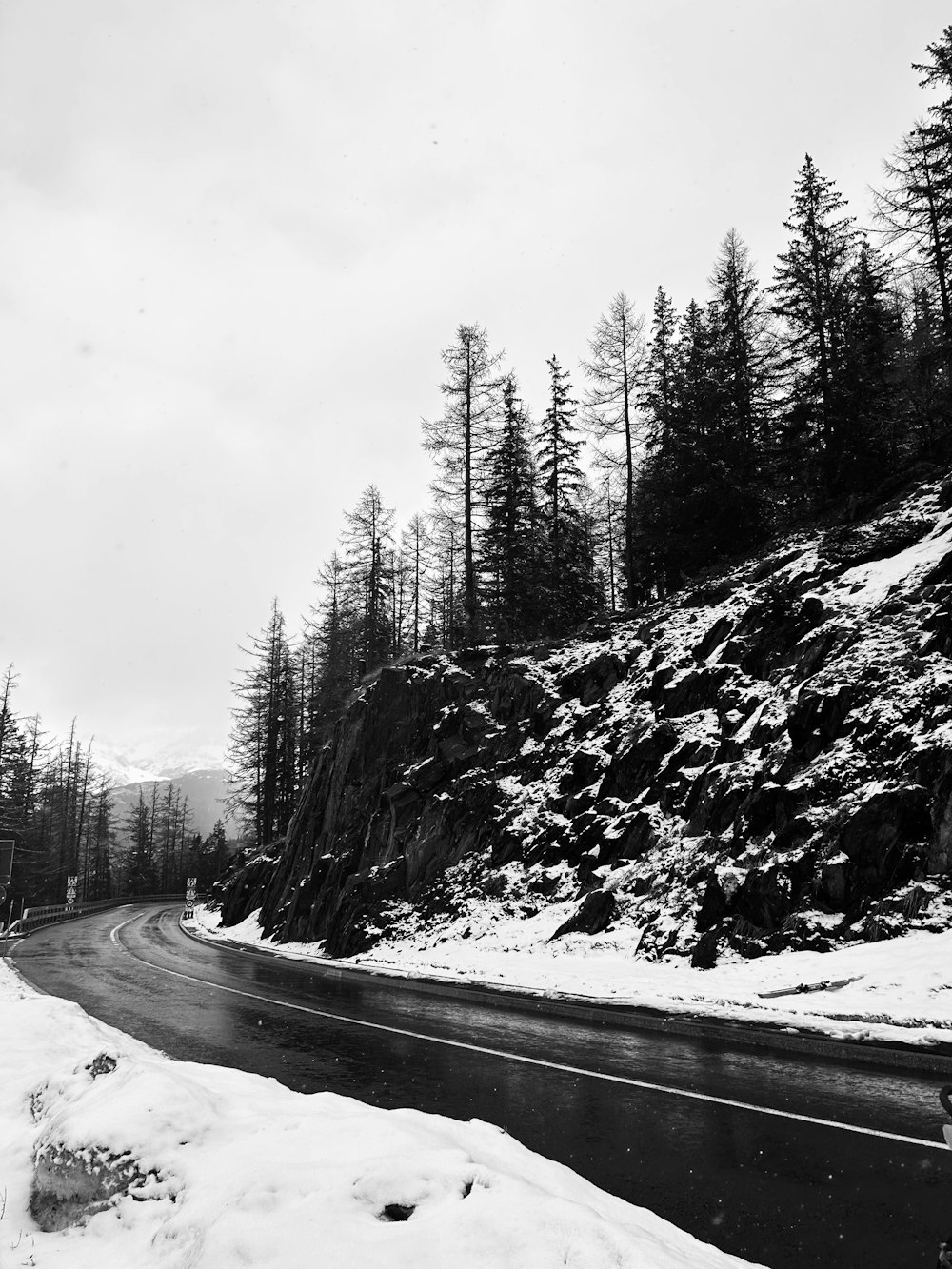 a black and white photo of a snowy road