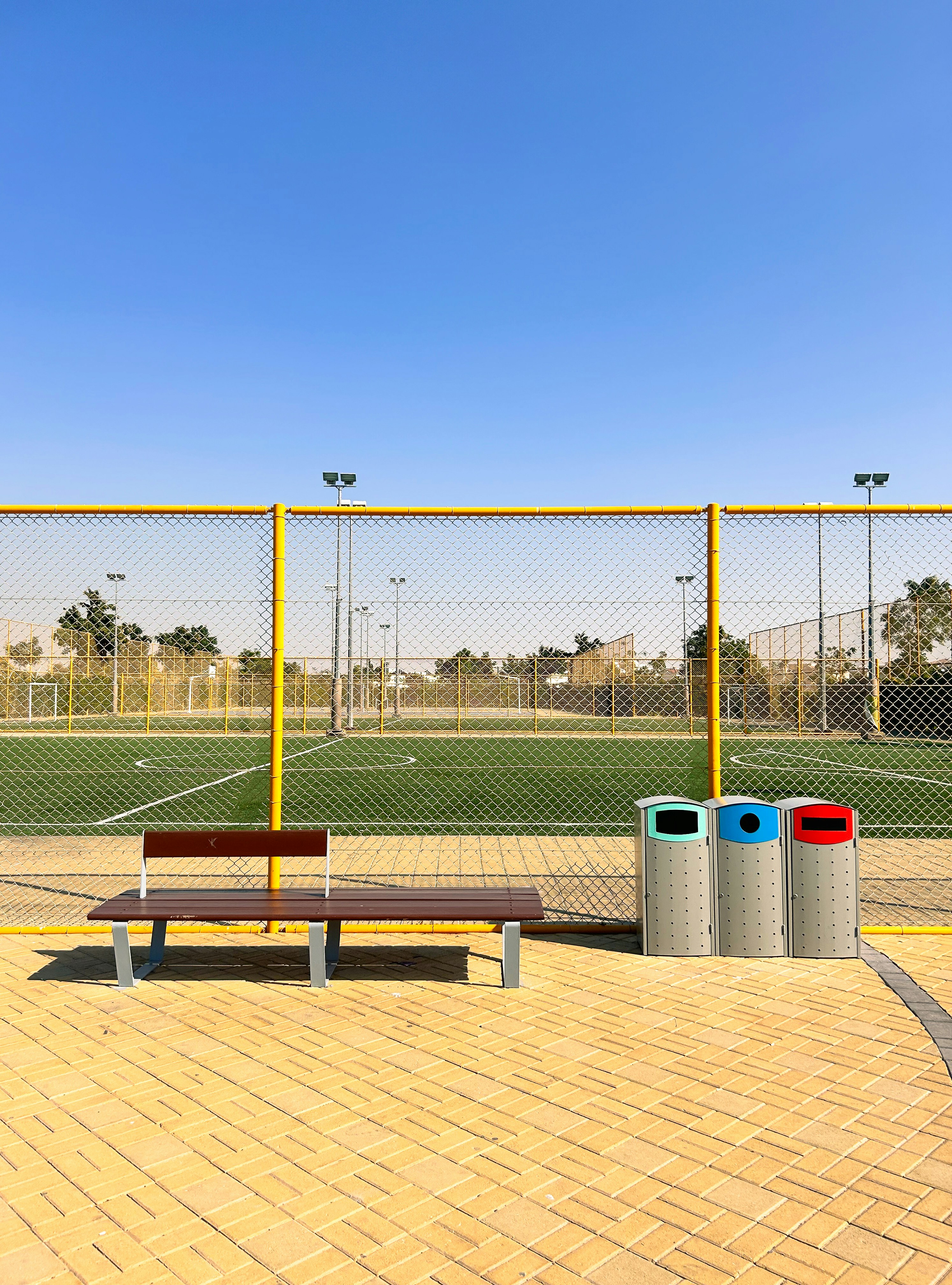 eine Holzbank vor einem Fußballplatz