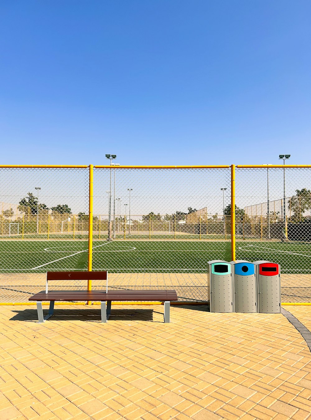 a wooden bench sitting in front of a soccer field