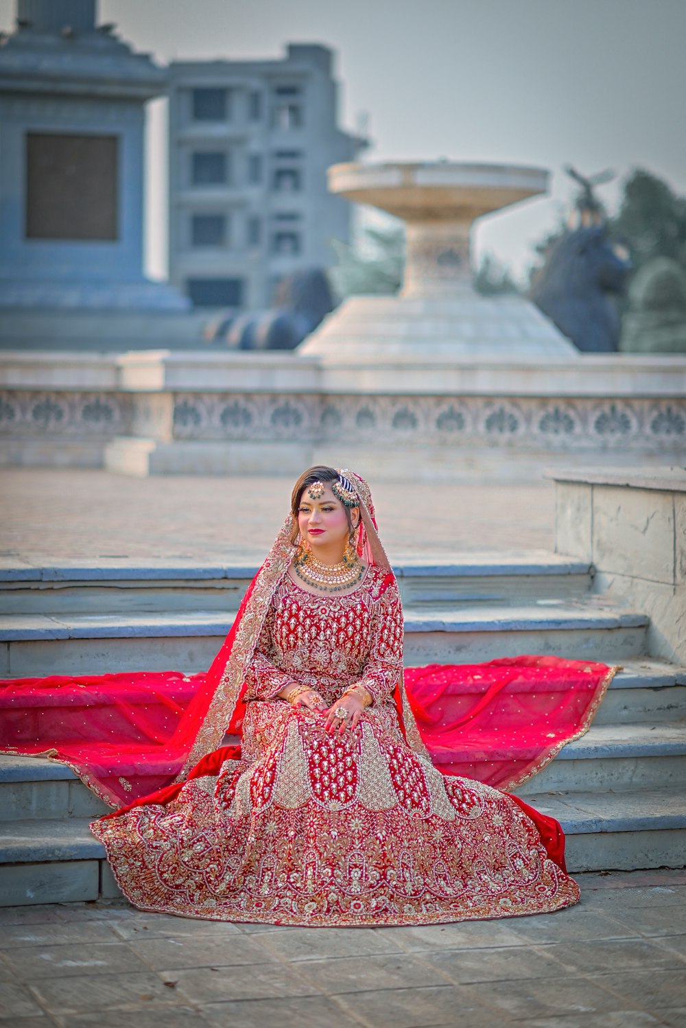 a woman in a red dress sitting on some steps