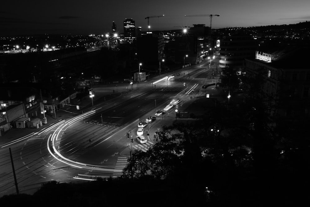 a black and white photo of a city street at night