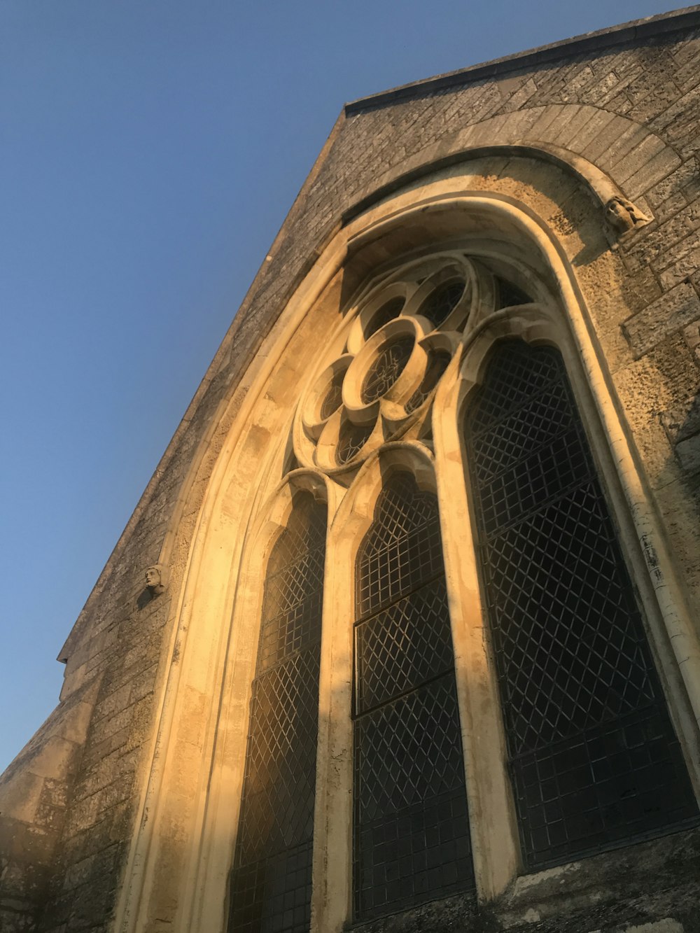 a stone building with a window and a sky background