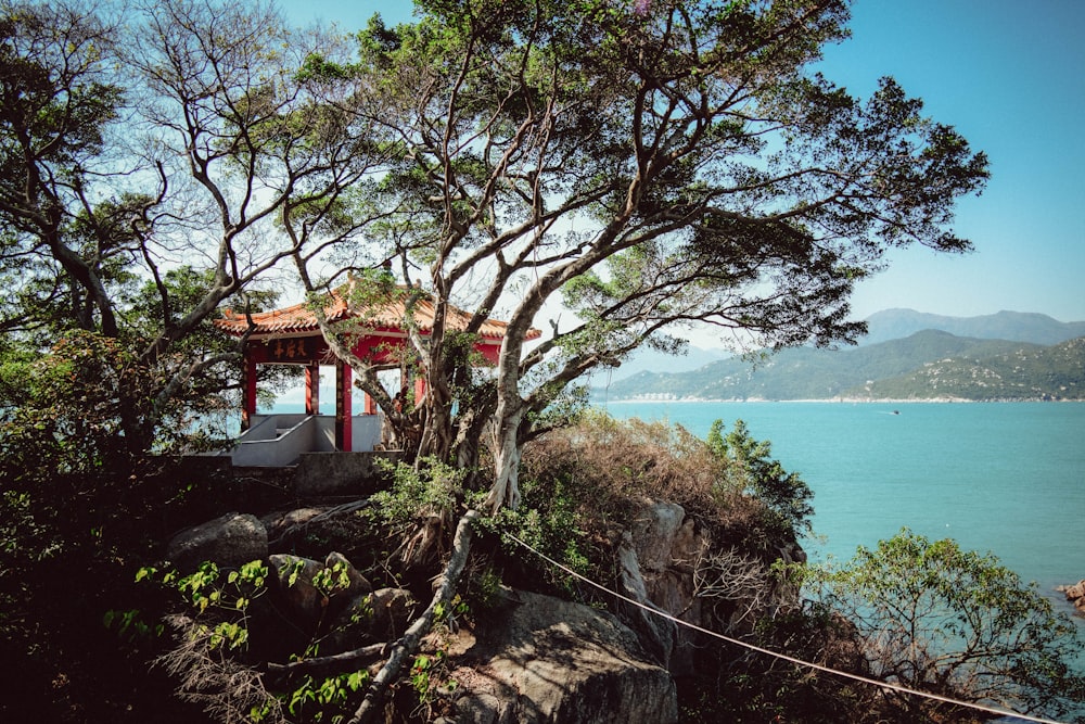 a gazebo sitting on top of a cliff next to a body of water