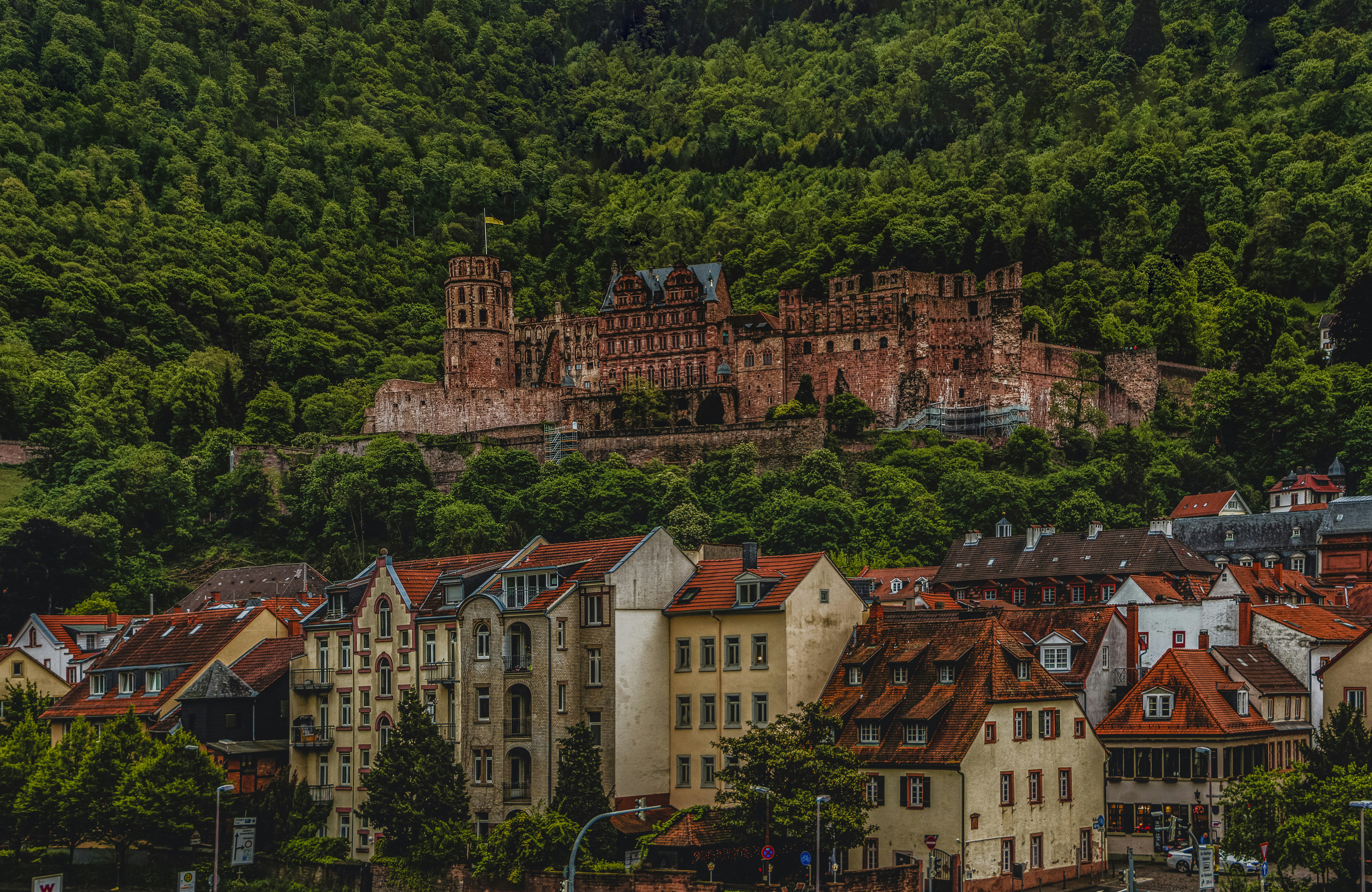 a group of buildings sitting on top of a lush green hillside