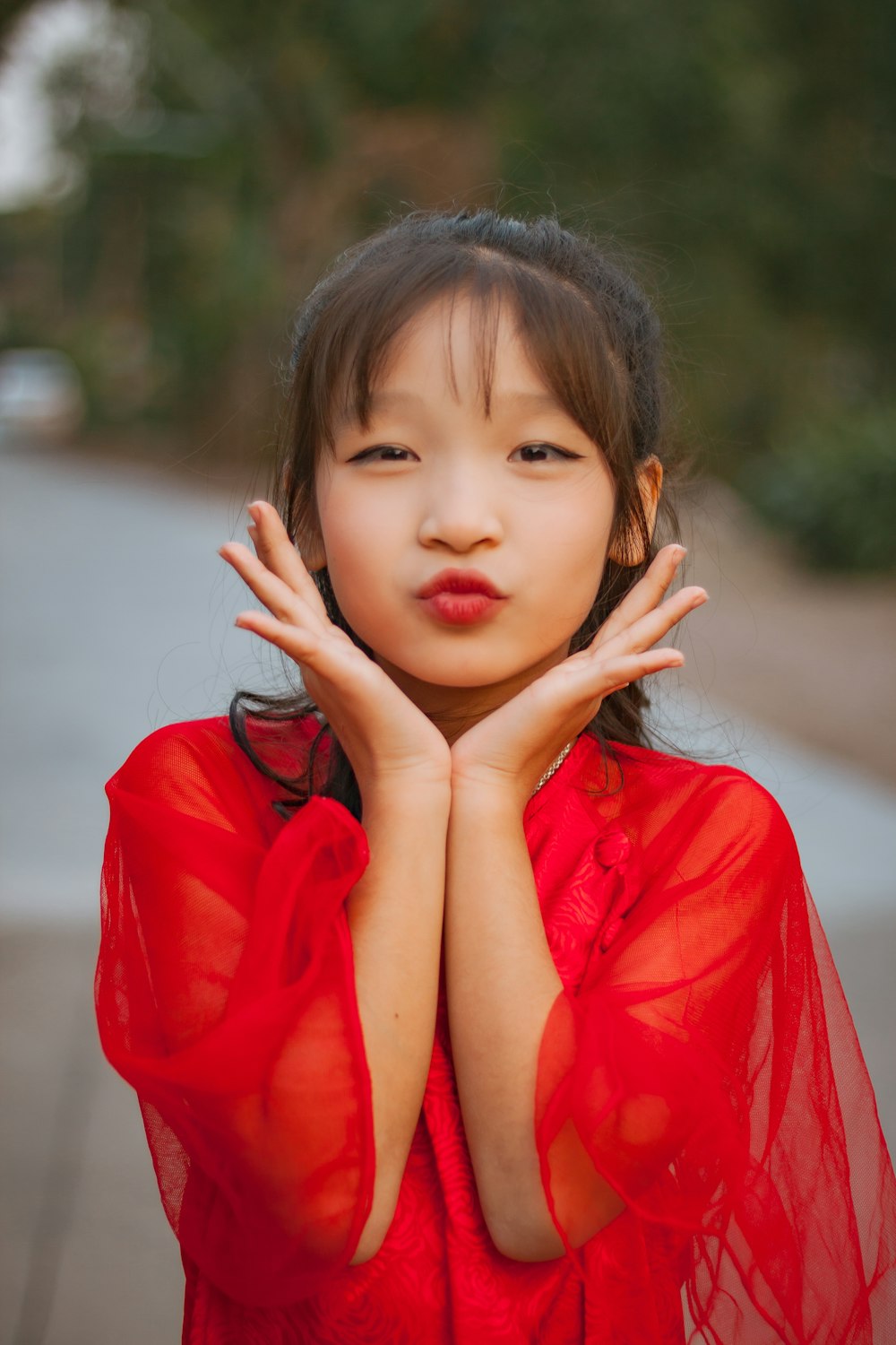 a woman in a red dress with her hands on her chest