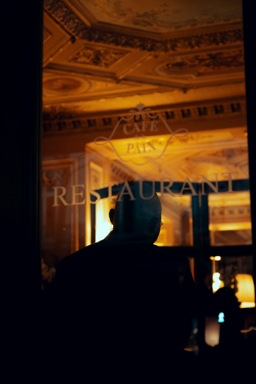 a man standing in front of a window at night