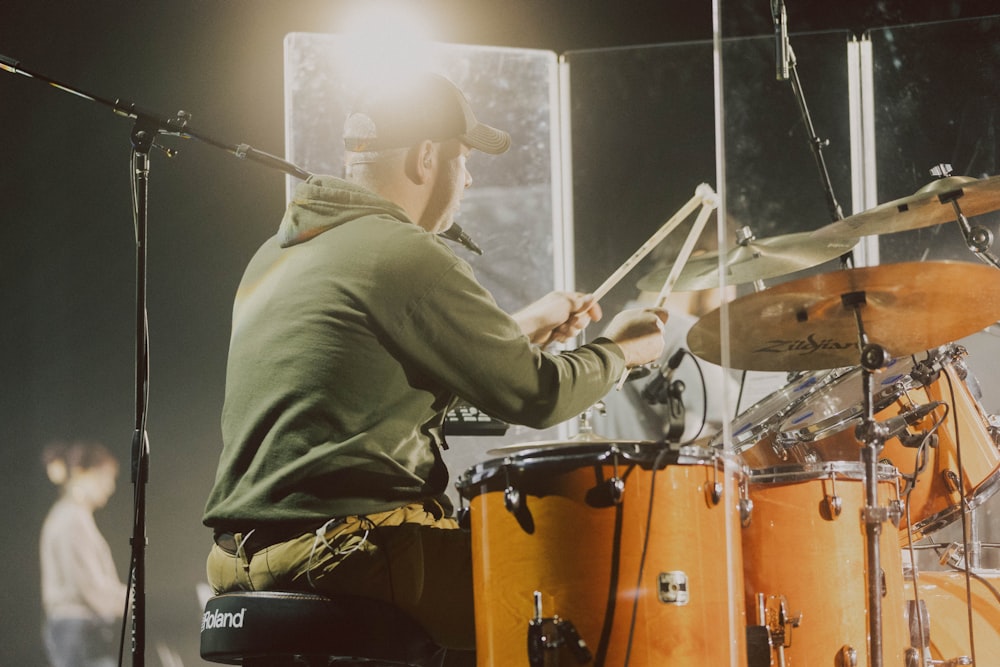 a man playing drums in front of a microphone