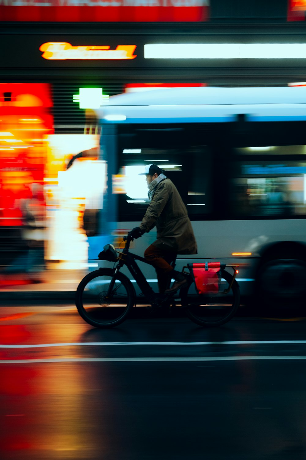 a man riding a bike down a street next to a bus