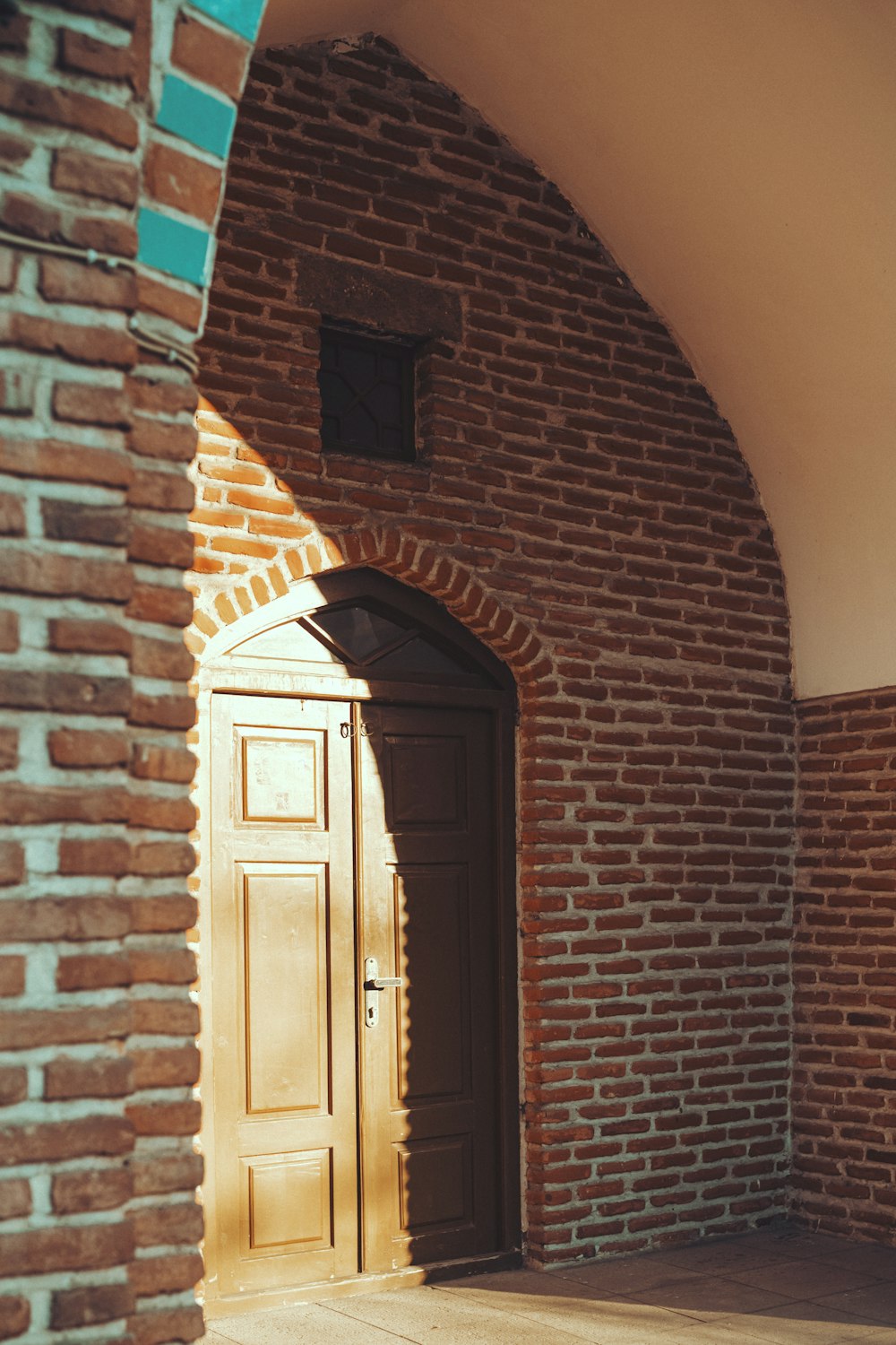 a doorway with a brick wall and a wooden door