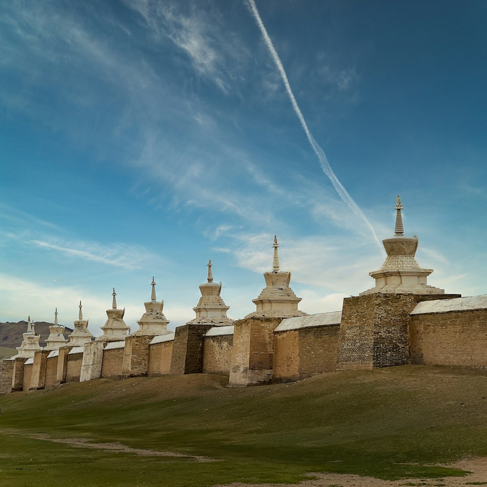 a group of buildings sitting on top of a lush green field