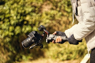a person holding a camera and a tripod
