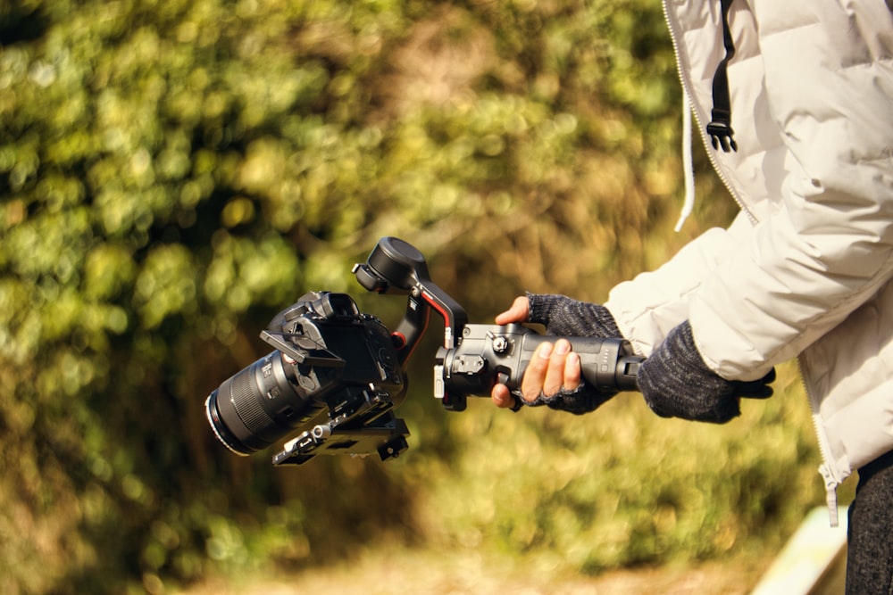 una persona che tiene una macchina fotografica e un treppiede