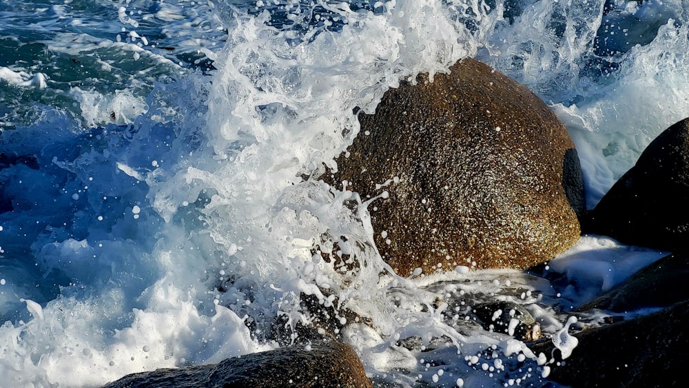 a large rock sitting on top of a body of water