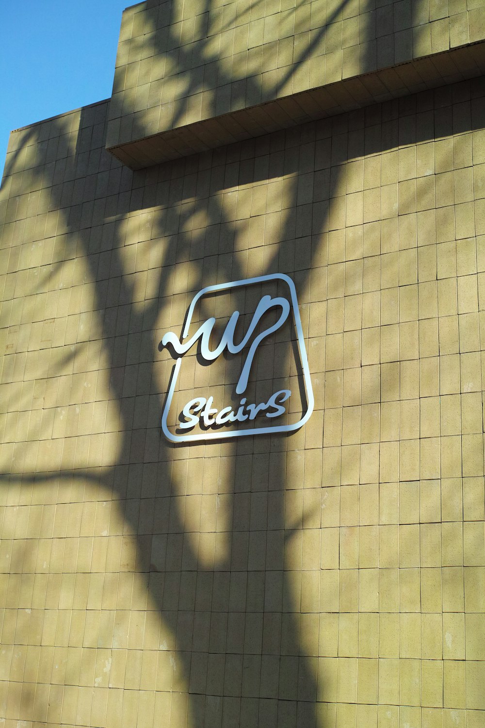 a sign on the side of a building that says up stairs