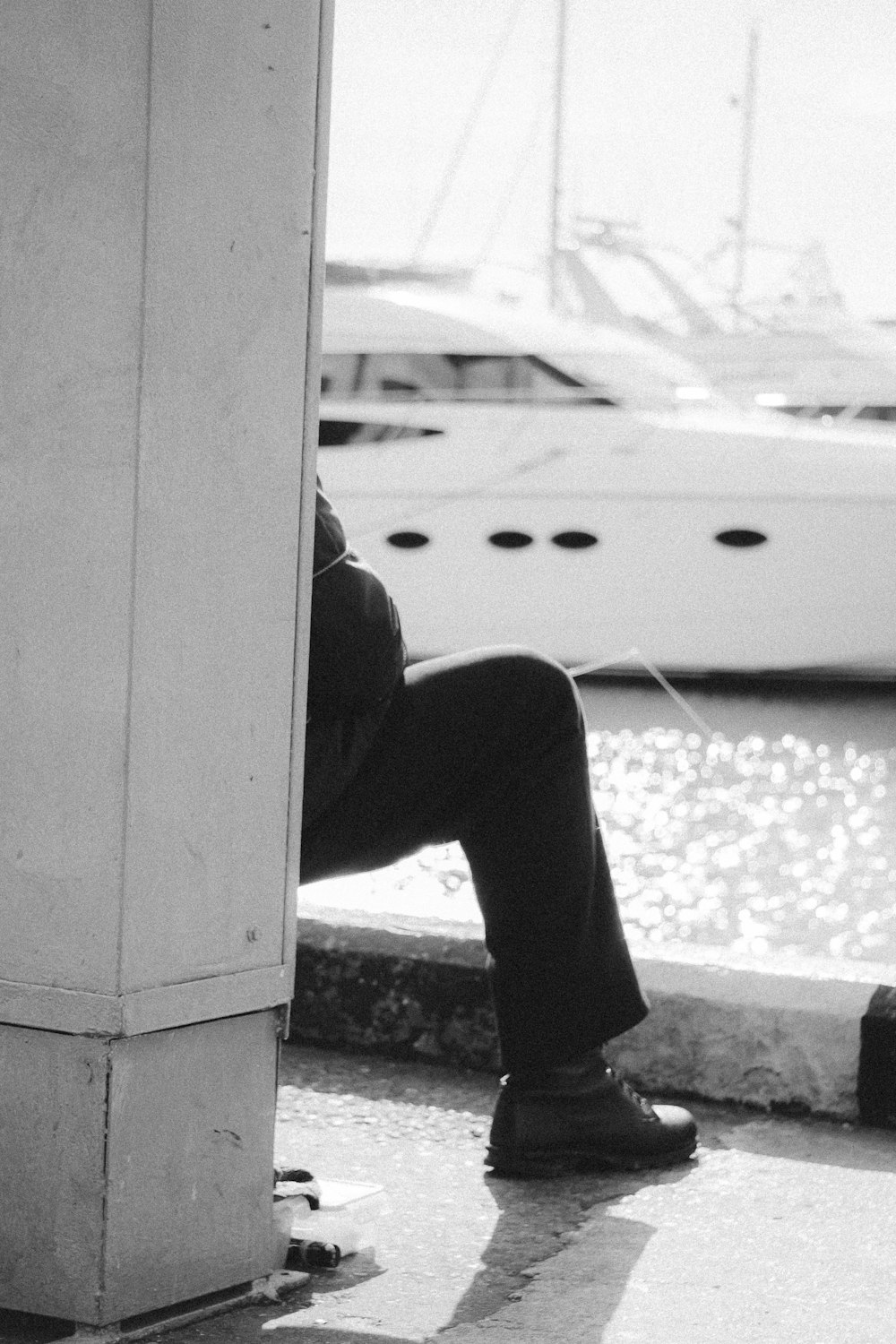 a black and white photo of a man leaning against a wall