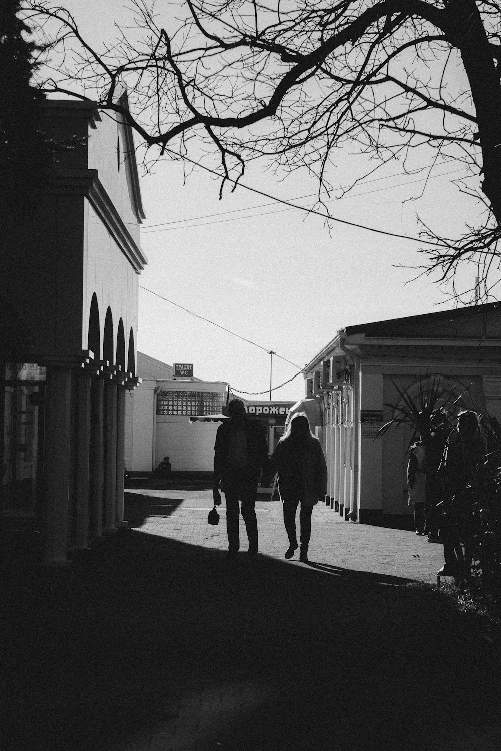 a couple of people walking down a street