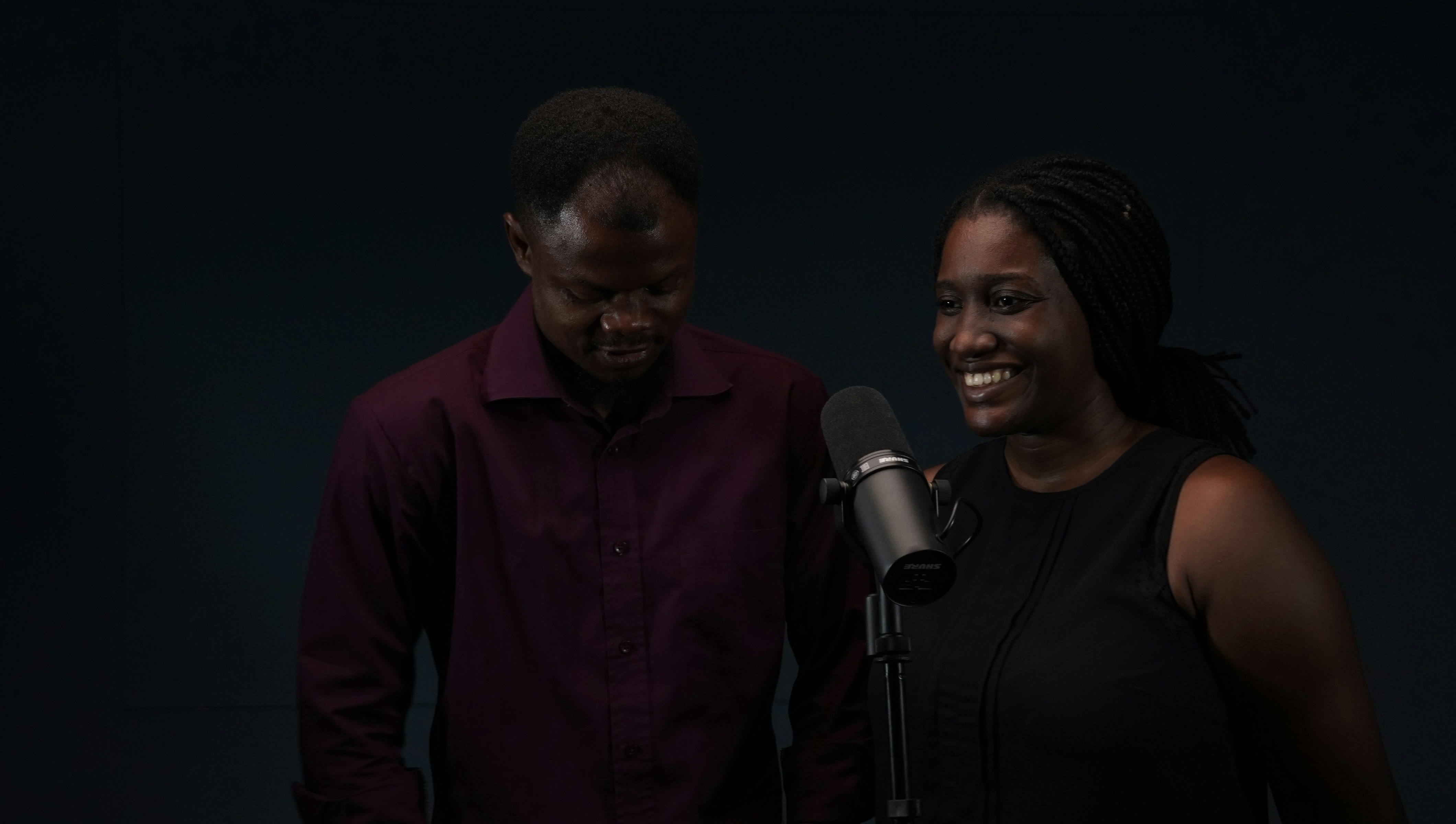 a man and a woman standing in front of a microphone