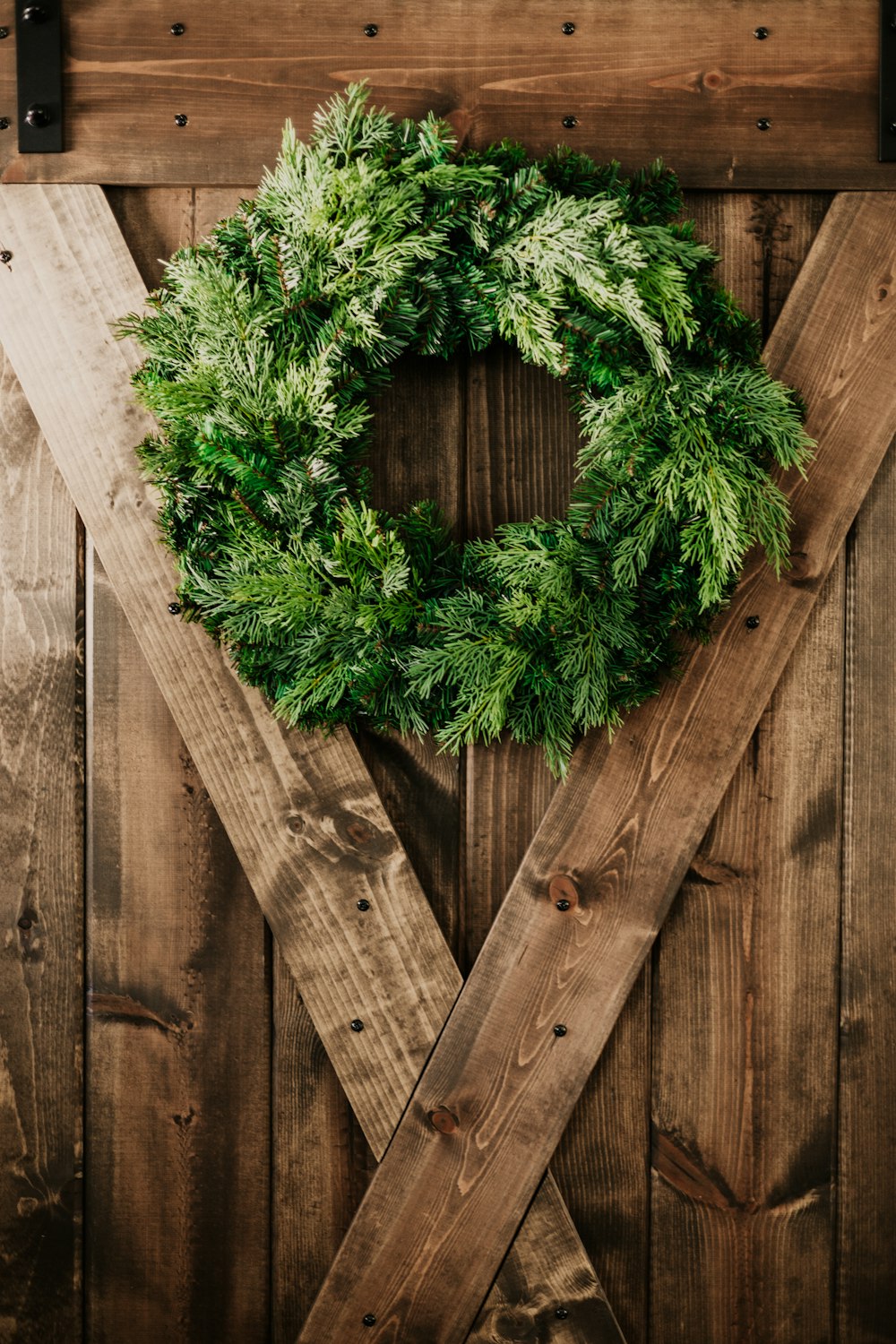 a green wreath is hanging on a wooden door