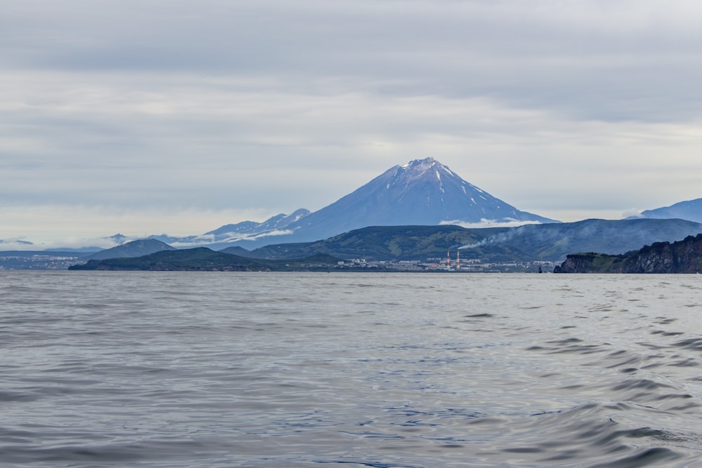 ein großes Gewässer mit einem Berg im Hintergrund