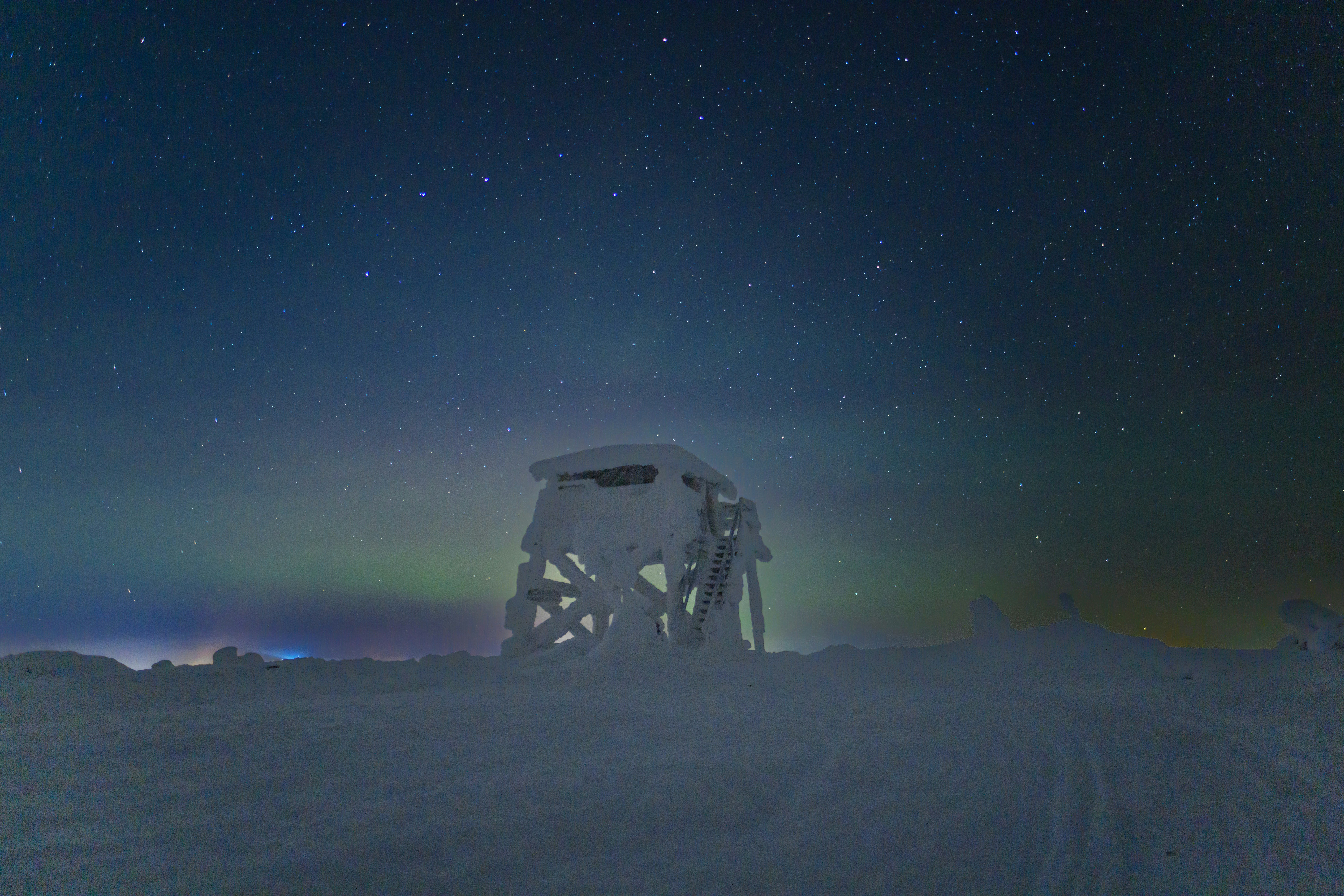 a radio tower sitting on top of a snow covered slope