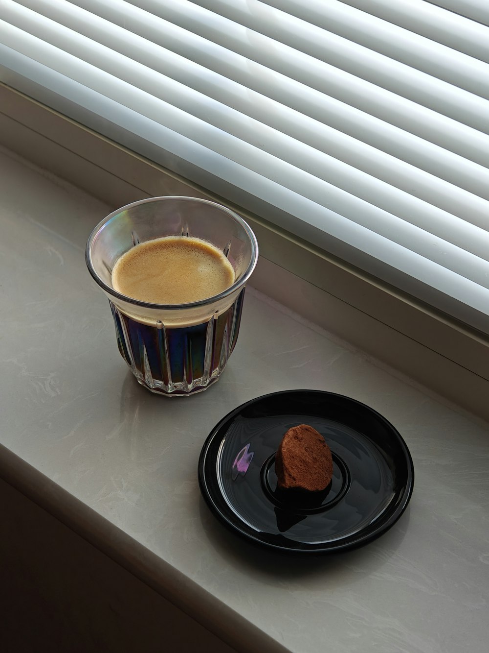 a cup of coffee next to a plate of food