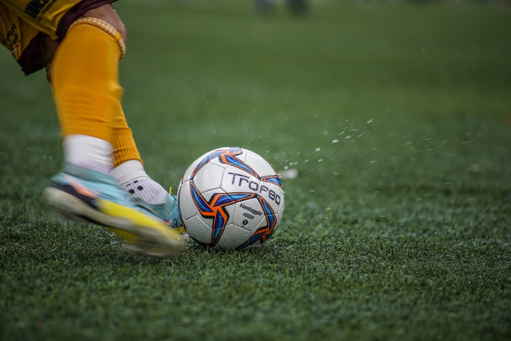 a person kicking a soccer ball on a field