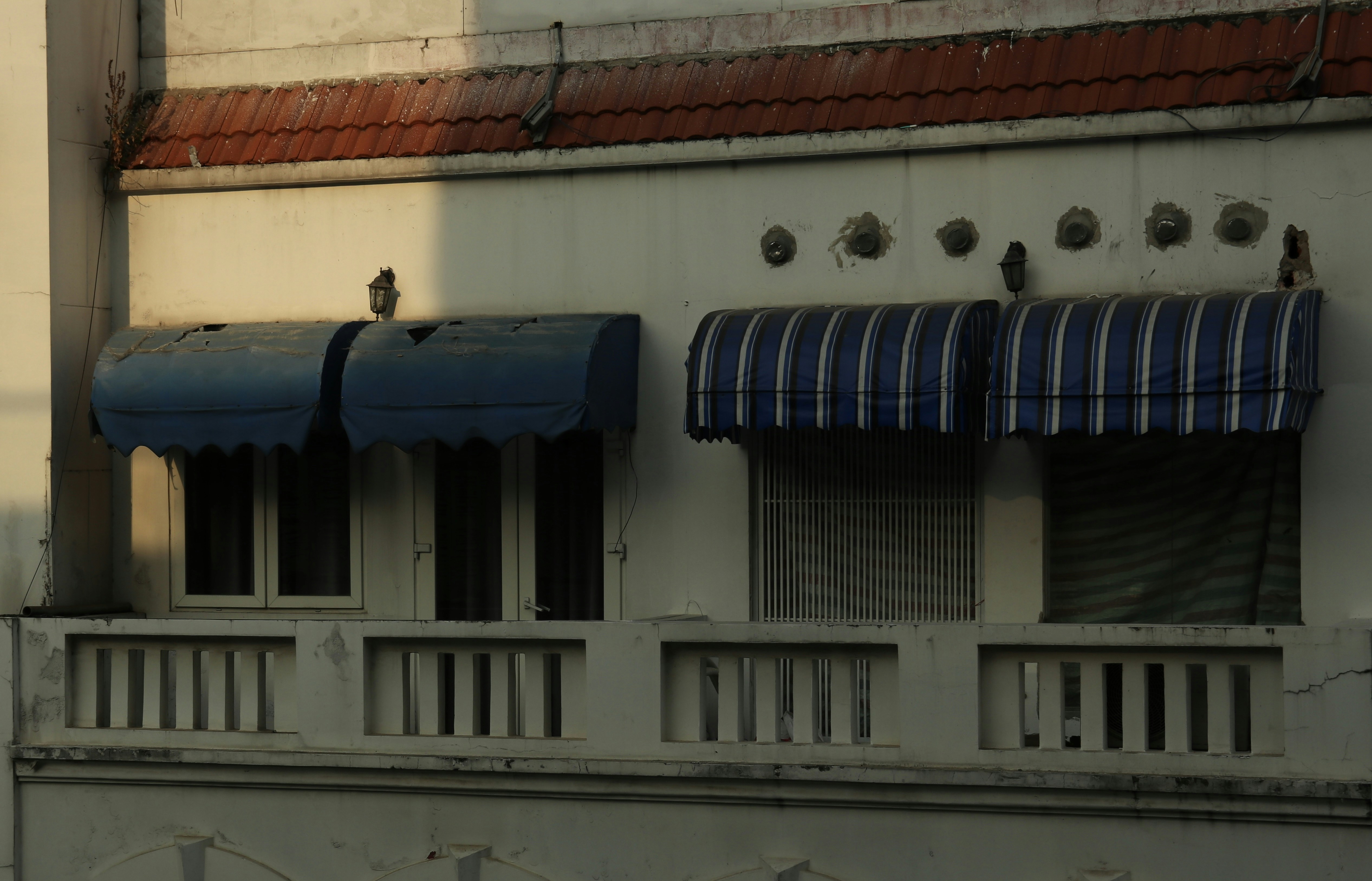 Comparison of a fixed window awning vs a motorized patio awning on a modern home