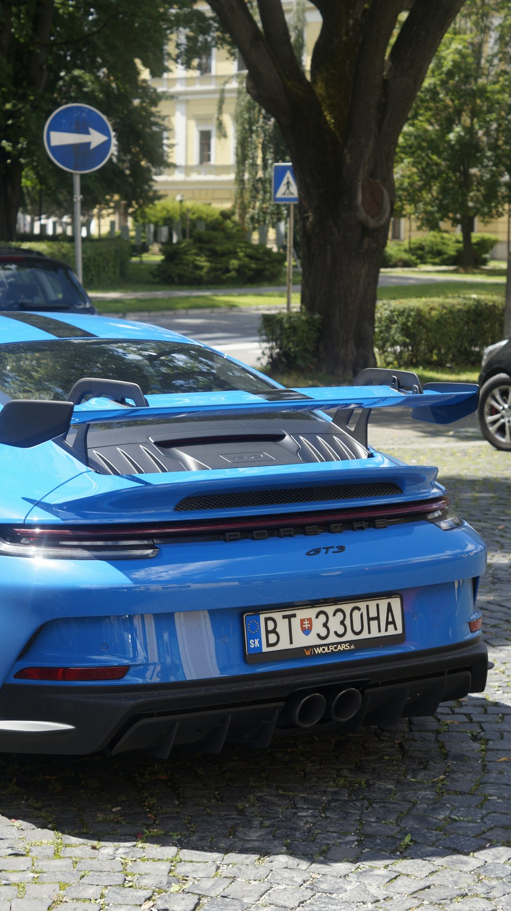 ein blauer Sportwagen, der am Straßenrand geparkt ist