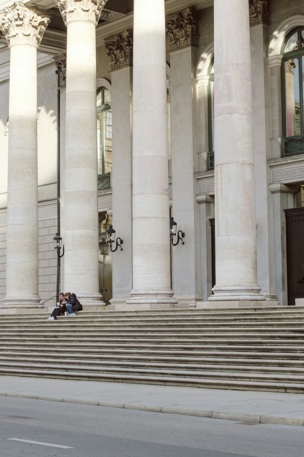 two people sitting on the steps of a building