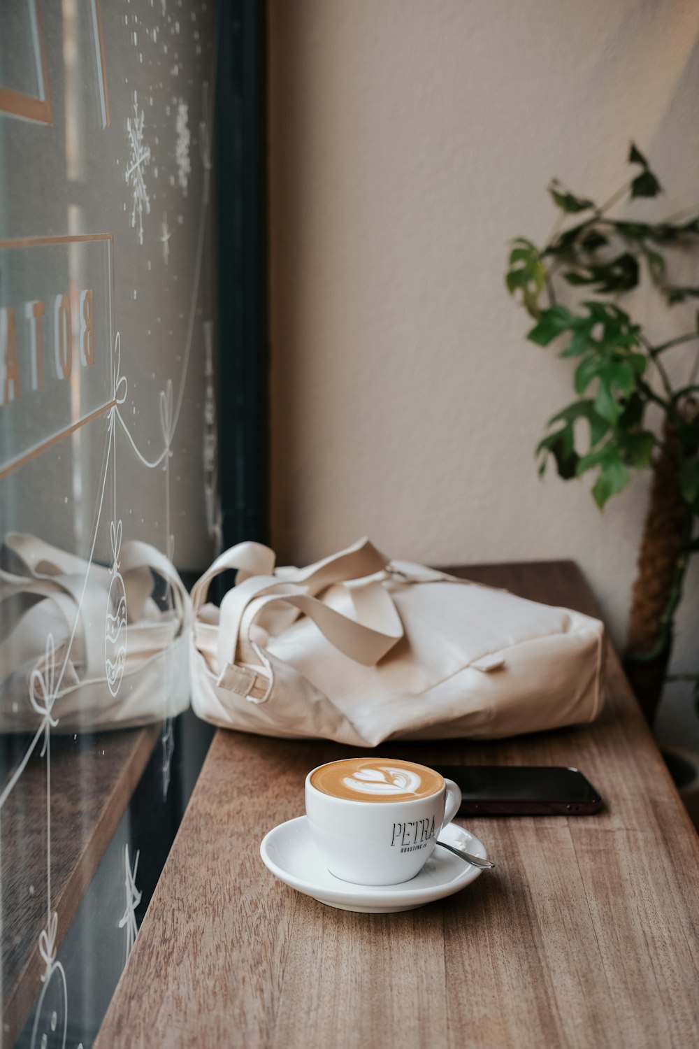 a cup of coffee sitting on top of a wooden table