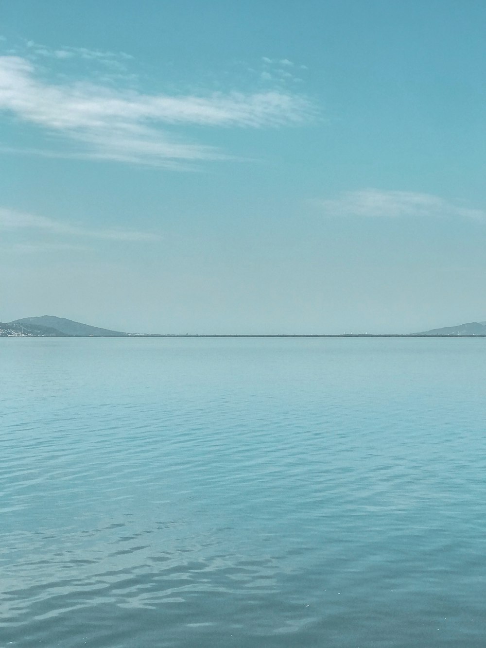 a large body of water sitting under a blue sky