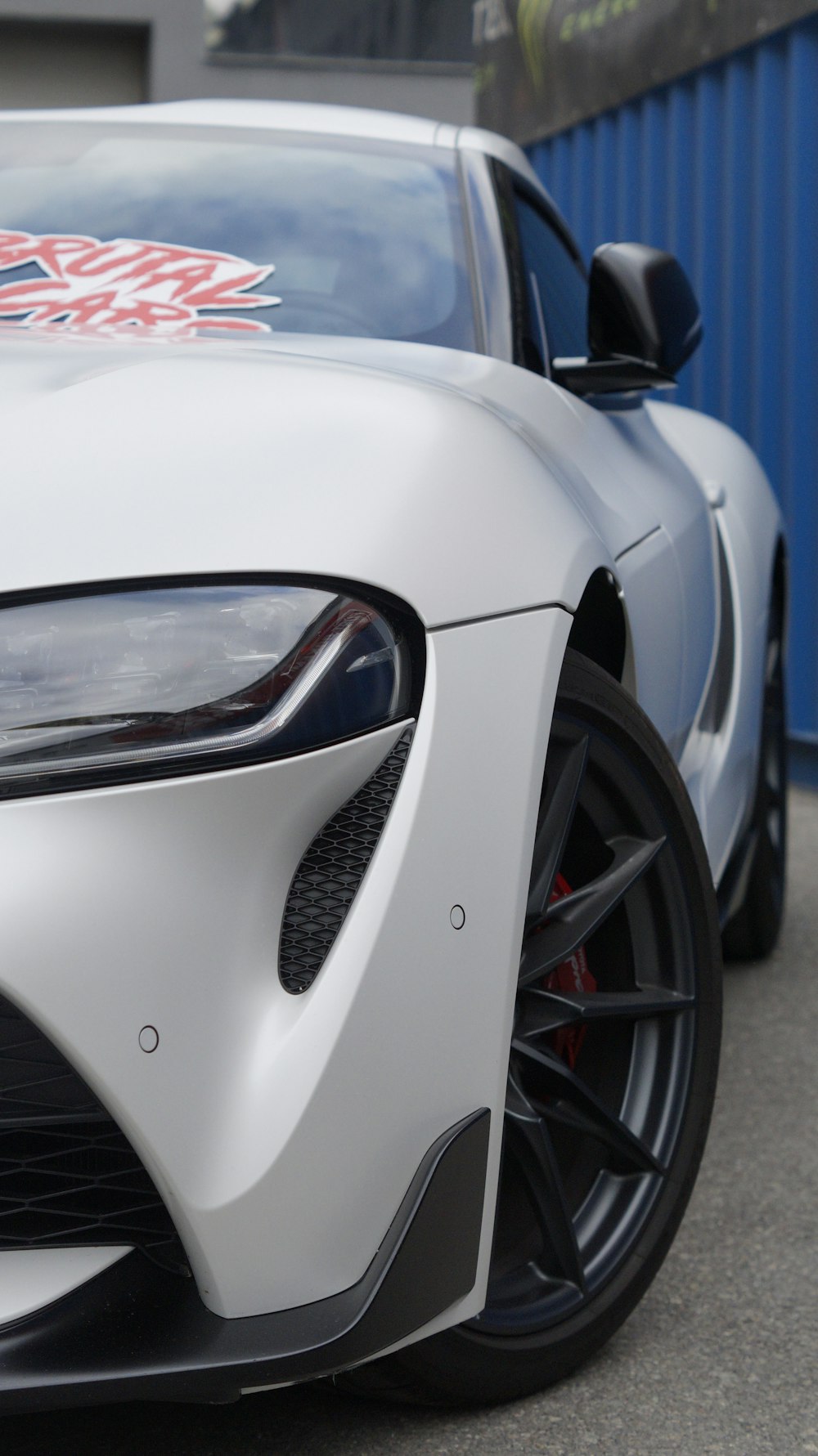 a white sports car parked in front of a building