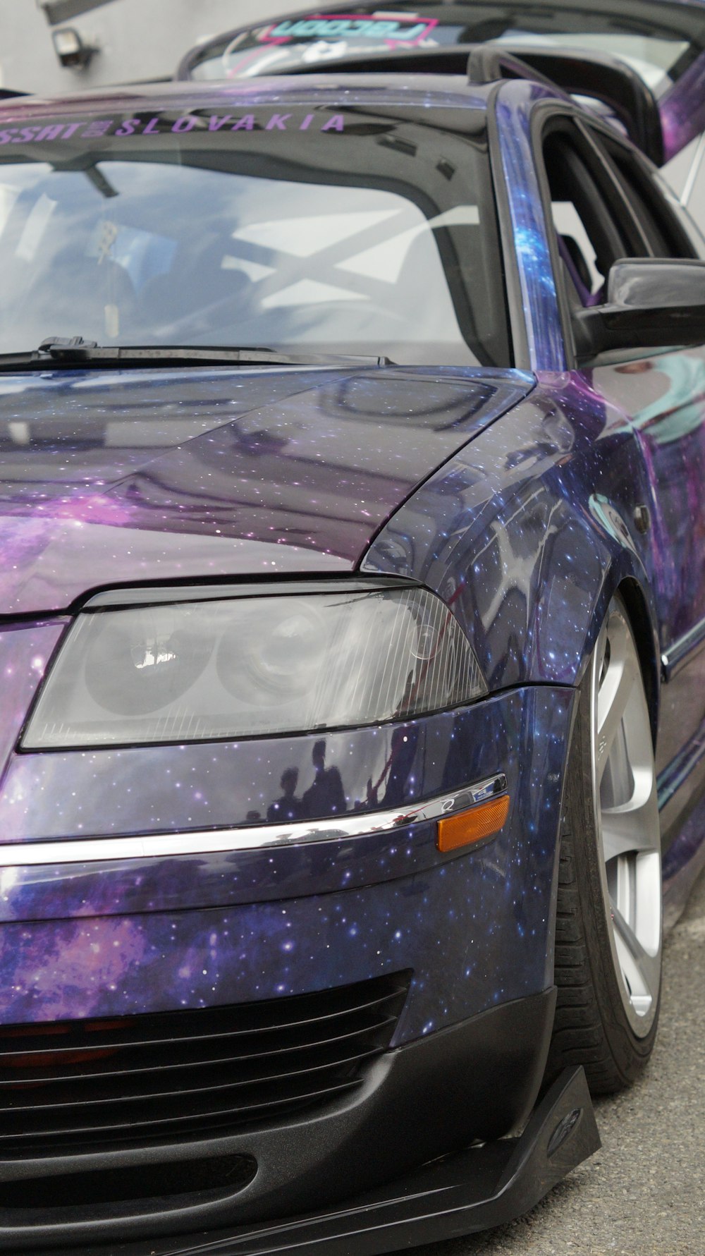 a purple and blue car parked in a parking lot