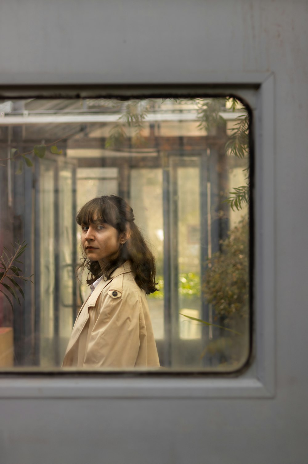 a woman standing in front of a glass window