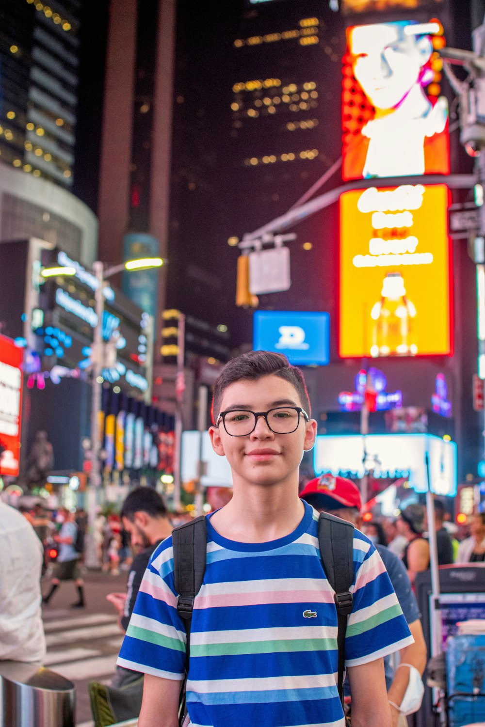 a young man standing in the middle of a busy street