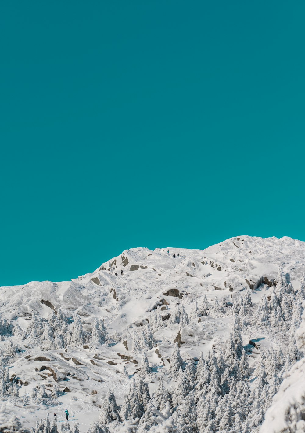 a man riding a snowboard down the side of a snow covered slope