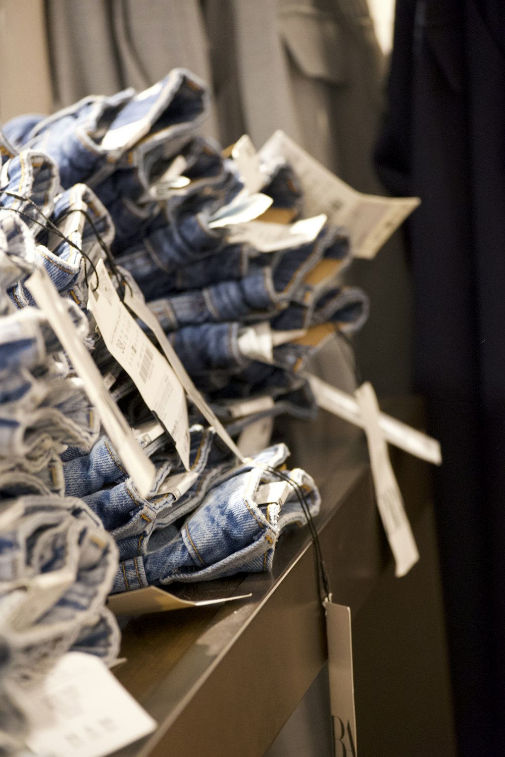 a pile of jeans sitting on top of a wooden table