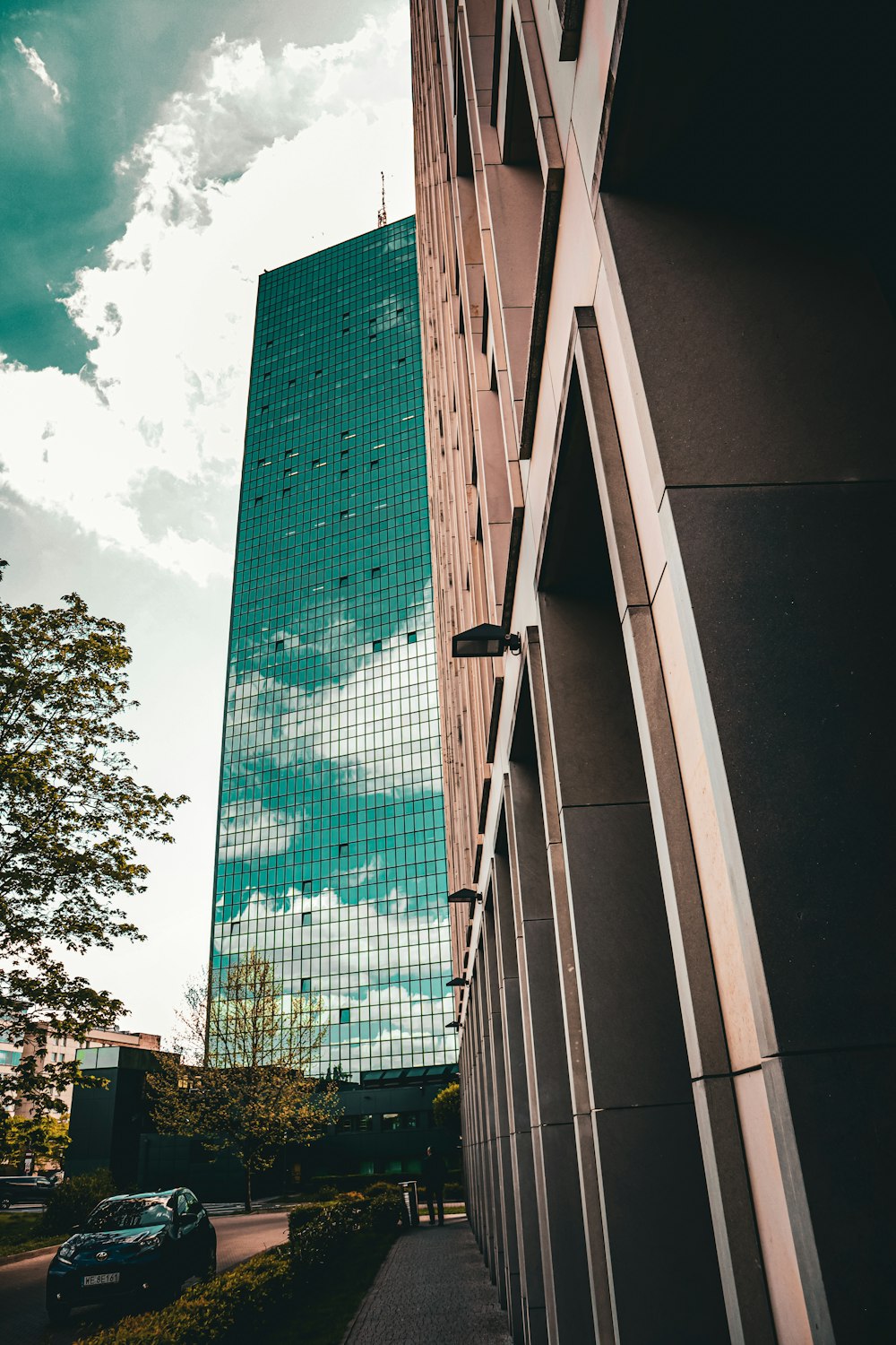 a tall building next to a street with a car parked in front of it