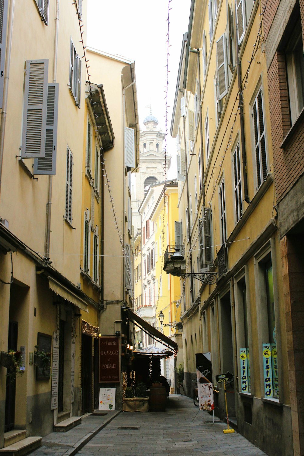 a narrow alley way with a clock tower in the background