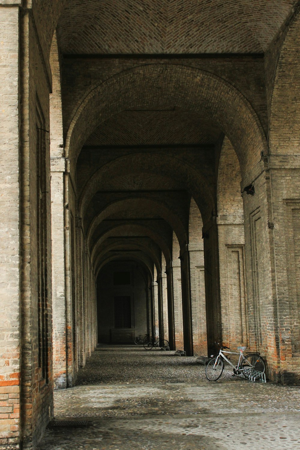 uma bicicleta está estacionada em um túnel entre dois edifícios