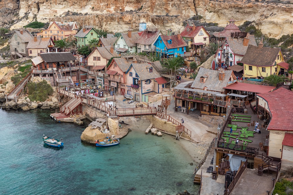 a group of houses sitting on top of a cliff next to a body of water