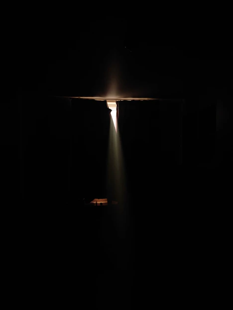 a dark room with a light coming from the ceiling