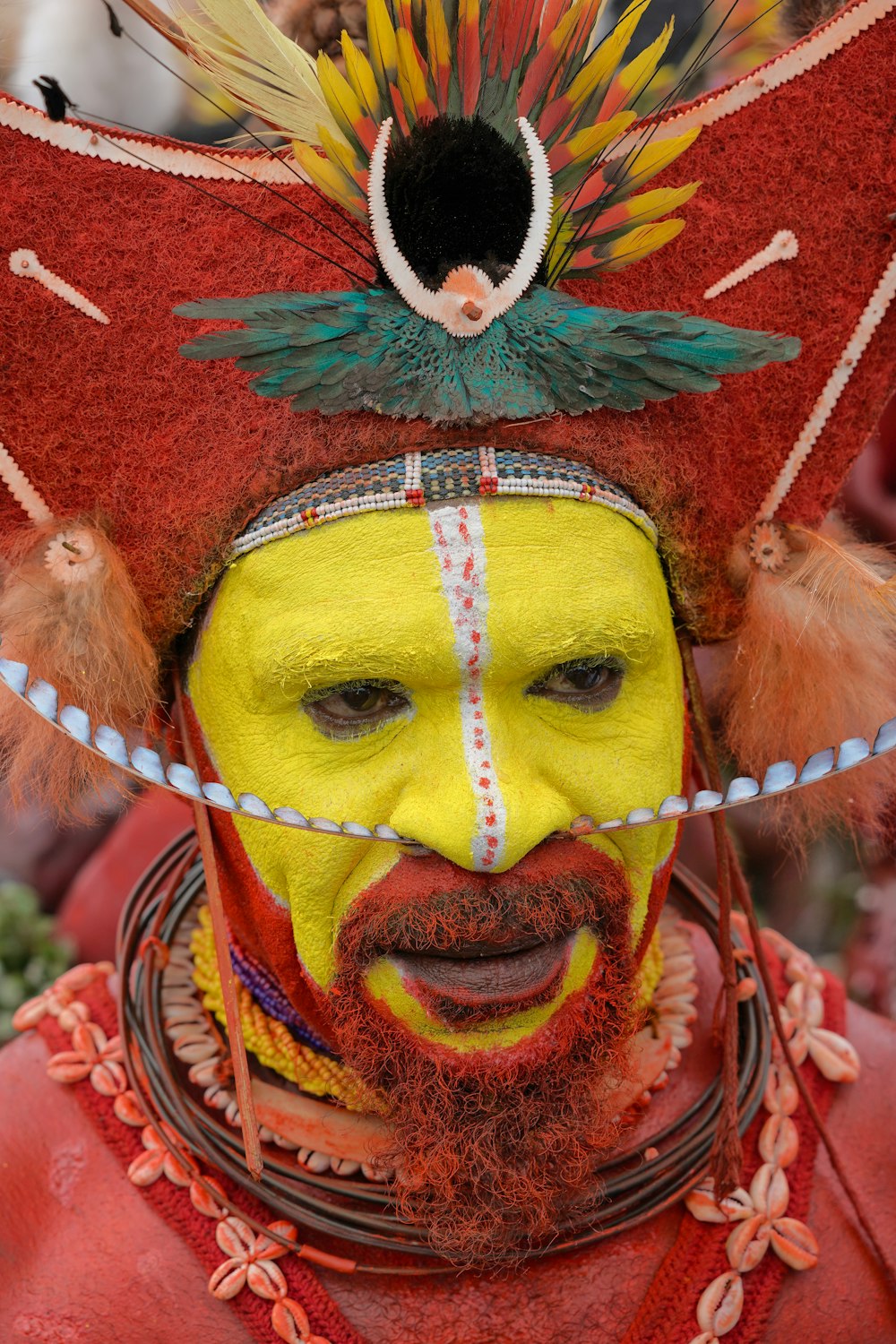a man with a yellow painted face and red hair