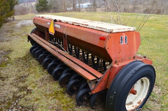 a large red tractor is parked in a field