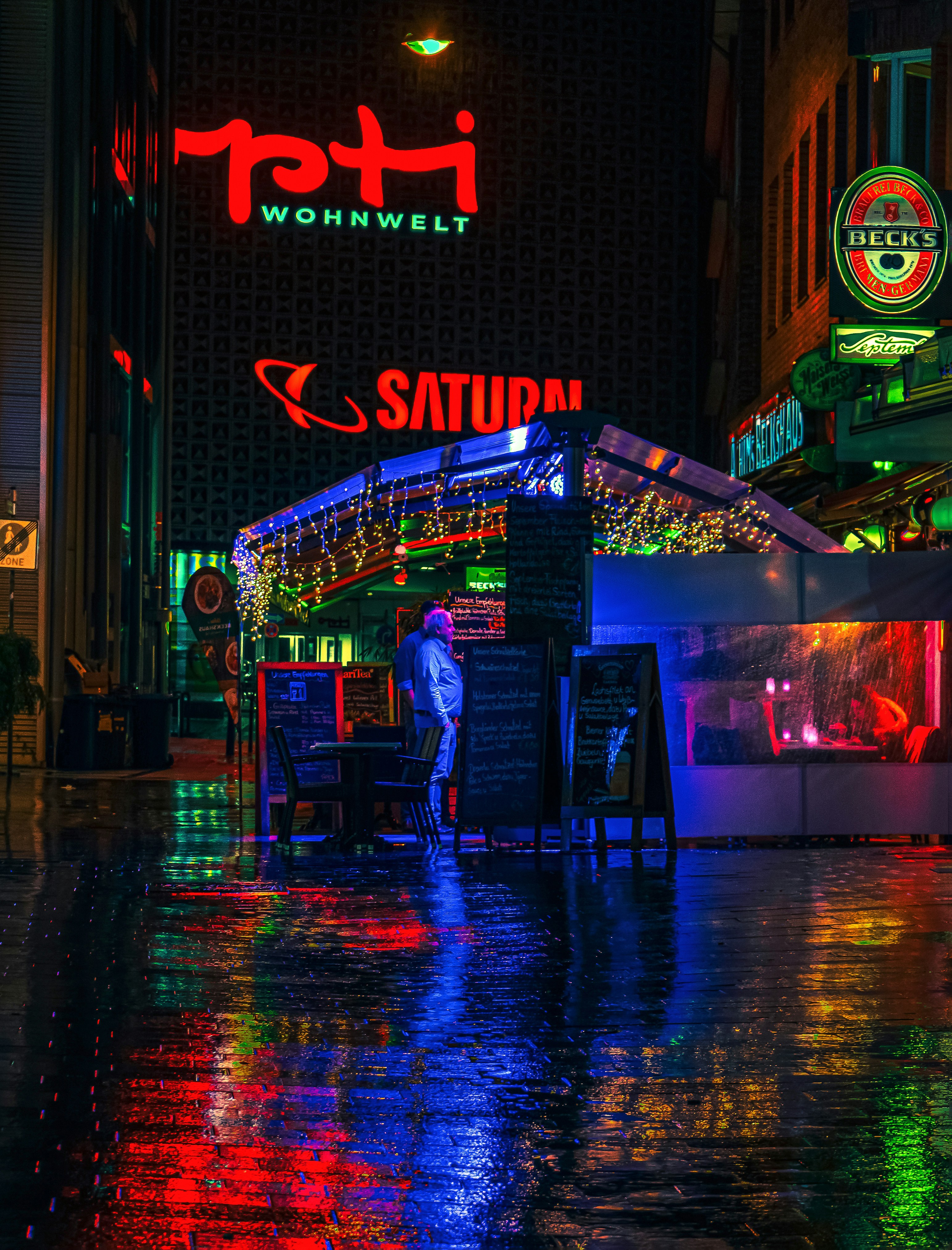 a man standing in the rain in front of a restaurant