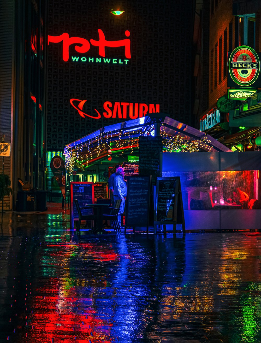 a man standing in the rain in front of a restaurant