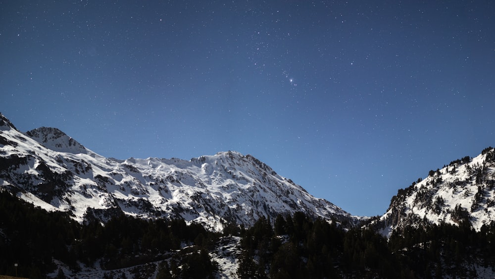 a snowy mountain range under a clear blue sky